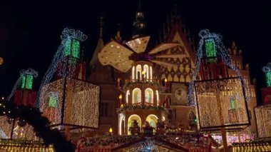 Christmas fair at night with illuminated gifts and festive carousel in historic city center. Festive Christmas market in Wroclaw, Poland. Concept of holiday celebration, winter tradition and tourism