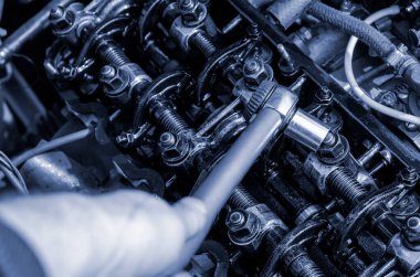 Yolcu vagonunun motor bölmesi. Silindir başını sıkılaştırıyorum. Özel bir tork anahtarıyla fındık kırma. Bir açıdan üstten bak. Seçici odak.