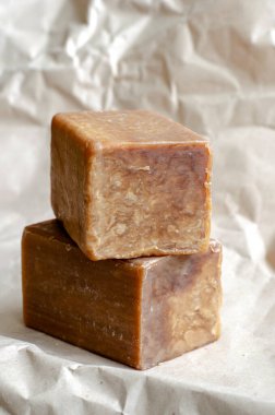 Sade arka planda iki parça çamaşır sabunu. Dikdörtgen şeklinde yeni sabun parçaları. Doğal hijyen ürünleri. Mesaj için yer. Seçici odak.