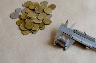 Bir kalibre bozuk para sayısını ölçer. Masanın üzerinde farklı değerlerde Ukrayna sikkeleri var. Yolsuzluk, finans, ekonomi. Bir açıdan üstten bak. Seçici odak.