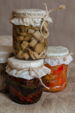 Konserve mantar, lecho ve diğer ev yapımı konserveler. Cam kavanozlarda konserve yiyecekler. Çuval bezinde çeşitli konserveler. Ekinlerin korunması ve depolanması. Yakın plan..