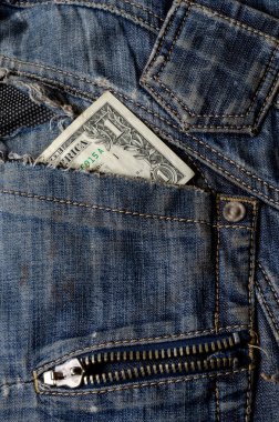 Yırtık kotun cebindeki dolar. Eski kot pantolona bir dolarlık banknot. Kriz konsepti, yoksulluk. Yakın plan. Boşluğu kopyala.