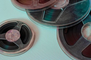 Birkaç plastik kaplama yakın plan. Aydınlık bir arkaplanda çok renkli ışınlarla ses kayıtları olan eski polis memurları. Çizik ve tozla dolu gerçek bobinler. 70 'lere geri dönelim Seçici odak.