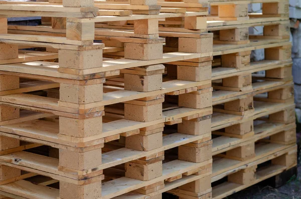 Empty wooden pallets outdoors. A stack of pallets for easy transportation and protection of various goods. Logistics and modern packaging. Selective focus.