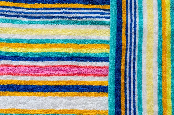 マルチカラーのストライプビーチタオルをクローズアップ 虹色のカラフルなタオル 肯定的な色 抽象的な背景 上からの眺め — ストック写真