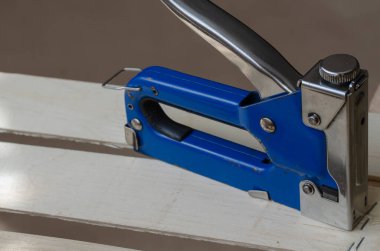 Endüstriyel zımba yeni bir tahta kutunun üzerinde duruyor. Sebze ve meyve ambalajı, depolama ve taşımacılığı için çevre dostu ahşap kaplar üretimi. Endüstriyel konular. Seçici odaklanma. Boşluğu kopyala.