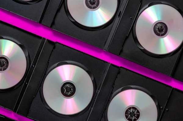 The evolution of digital media. SD Blu-ray discs in open black boxes on a purple background. View from above. Creative background
