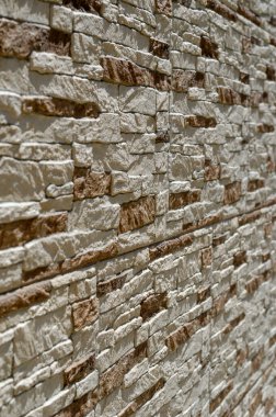 Binanın düzensiz dış duvarının dokusu. Geri çekilen bir perspektifte bir binanın dış görüntüsü. Modern mimari. Seçici odak.