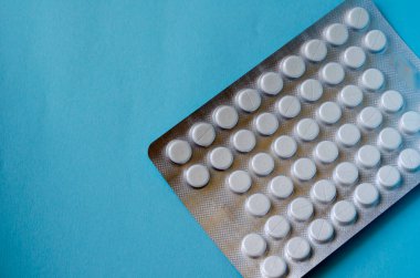 Yaratıcı arka plan tıbbi teması. Turkuaz arka planda bir sürü hapla su toplamış. Uzayı kopyala Göz hizası atışı.