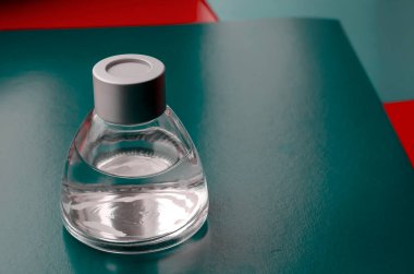 Renkli arka planda sıvı bulunan cam şeffaf şişe. Kırmızı-yeşil arka planda gümüş kapaklı küçük bir baloncuk. Yakın plan. Seçici odak.