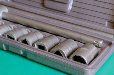 Bir dizi uğursuz anahtar. Metal tuşlu gri plastik bir kutuya yakın çekim. Elle kumanda. Seçici odak.