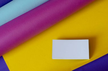 Çok renkli bir arka planda boş bir kartvizit. Gölgeli beyaz kartvizitler. Mavi, turkuaz, mor, sarı. Reklam, markalaşma. Yukarıdan görüntüle.