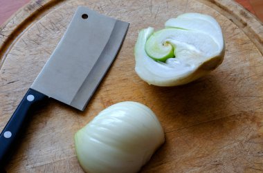 Süslü çiğ soğan. Kesme tahtasının üzerinde yarım yamalak soğan. Doğanın şakaları. Seçici odak.