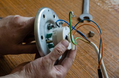 Su ısıtıcısının 26. bölümünün ısı düzenleyicisinin kurulumu. Uzman, termostatın elektrik bağlantılarını kazan dairesine bağlıyor. Ev aletleri onarım hizmetleri.