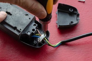Elektrikçi tornavidayla elektrik dağıtıcısını monte ediyor. Elektrik kablosu tamiri. Elektrik emniyeti. Bir açıdan üstten bak. Seçici odak.