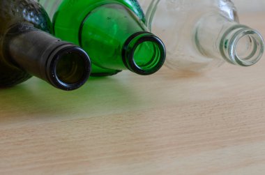 Toz ve kir dolu üç cam şişeye yakın çekim. Masada üç boş bira şişesi var. Alkol bağımlılığı konsepti. - İçki. Sosyal bir mesele. Boşluğu kopyala.