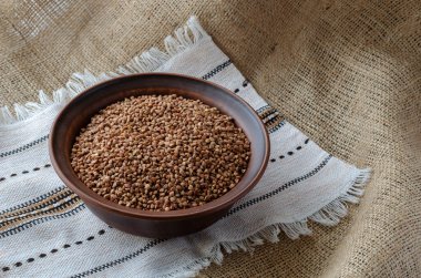 Kil kasede kuru karabuğday servisi. Keten havluyla çuval bezinde geleneksel yulaf lapası yapmak için. Bir açıdan yan görüş. Seçici odak.