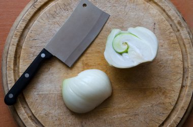 Süslü çiğ soğan. Kesme tahtasının üzerinde yarım yamalak soğan. Doğanın şakaları. Yukarıdan görüntüle.