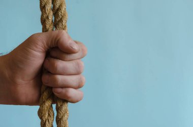 Bir adamın elinde kenevir ipi. El kalın bir doğal kabloyu tutar. Avrupa ırkından yetişkin bir erkek. Etkileşim kavramı.