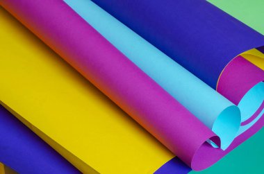 Ekmeklere sarılmış renkli kağıtlar. Çeşitli tasarım görevleri için yaratıcı arka plan. Bir açıdan yan görüş. Uzayı kopyala Seçici odak.