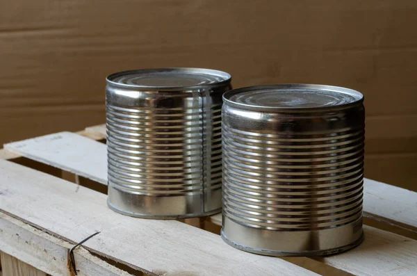 Canned food in cans. Two metal shut jars of ready-to-eat food. Long-term food products. Top view at an angle. Selective focus.