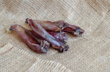 Evcil hayvanlar için kurutulmuş tavşan kulakları. Çuval bezinde beş çiğneme ikramı. Doğal diş tedavileri. Hayvan malzemeleri. Seçici odak.