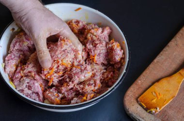 Doldurulmuş tatlı biberler için et hazırlığı. 4 'ün 1' i. Erkek eli kıyma, pirinç ve kızarmış sebzeleri metal kasede karıştırdı. Yan görüş. Seçici odak.