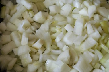 Kesik beyaz soğan arkaplanı. Çiğ soğan parçaları yakın plan. Bir açıdan üstten bak. Seçici odak.