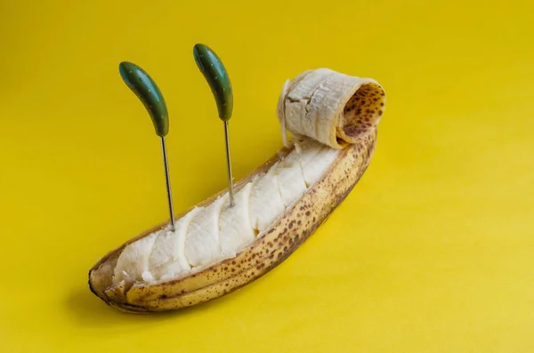 过熟的香蕉 有部分剥皮的皮和有壳的扭曲物 黄色背景下的甜果片 侧视图 有选择的重点 — 图库照片