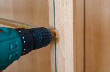 Dolap kapısına cam döşeme. Elektrikli tornavida kullanarak mobilyaların montajı ve onarımı. Ticari hizmetler. Kapalı alanda çekim yapmak. Seçici odak.