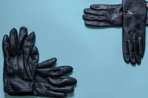 ライトブルーの背景にブラックレザー手袋 オスとメスの手袋のペア 角度でのトップビュー — ストック写真