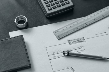 Masanın üzerinde ev suyunun çizimi olan bir sayfa kağıt. Malzemelerin hesaplanması ve çalışma düzenlenmesi. Tesisat servisi. Tek Renkli