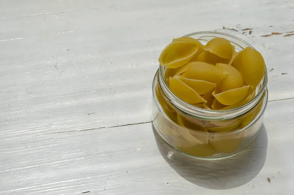 Raw Conchiglie Pasta Glasburk Vit Trä Bakgrund Närbild Servering Okokt — Stockfoto