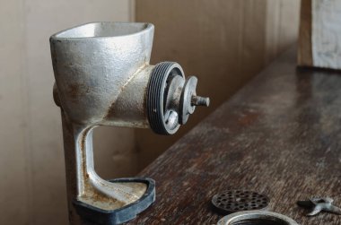 Tahta masada parçalanmış eski model kıyma makinesi. Çeşitli ürünleri öğütmek için el aleti. Antika mutfak aletleri..