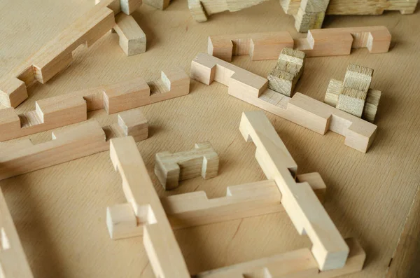 Details of the children\'s wooden constructor randomly on the wooden table. Close-up of a developing children\'s toy. Selective focus. Copy space.