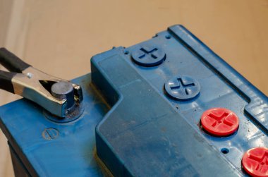 Şarjlı akü terminali negatif. 12 voltluk pili şarj etme süreci. Topraklı ve tozlu eski batarya. Otomobil elektrikçisi. Araba servisi..