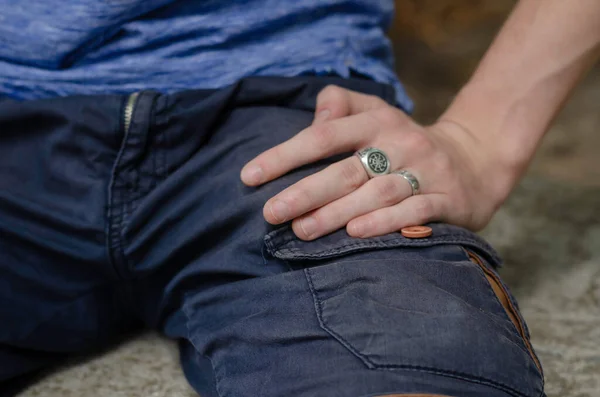 年轻的白人男性的手躺在他的髋部 手拿着银戒指和戒指男人坐在外面休息 生活方式 有选择的重点 — 图库照片