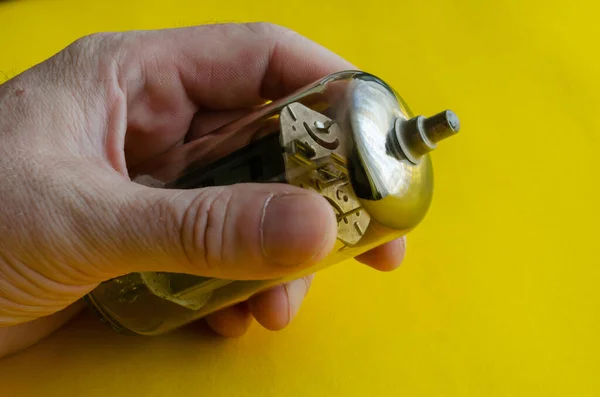 Male hand holds a vacuum tube on a yellow background. A radio tube that came out of the operation in a male hand. Collecting radio parts or recycling. Selective focus.