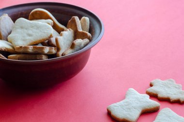Kırmızı arka planda ev yapımı kurabiyeli kahverengi toprak kap. Geleneksel tatil ürünleri. Uzayı kopyala Yan görüş. Seçici odak