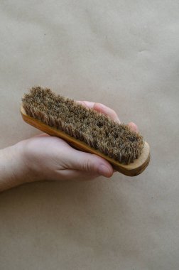 Beyaz, orta yaşlı bir adam elinde tahta bir fırça tutuyor. Eski, çatlak bir fırça. Seçici odak.