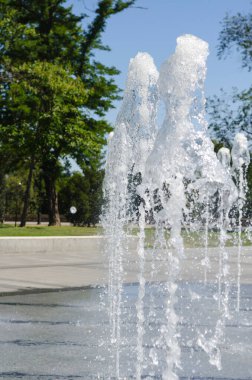 Şehir meydanında fıskiye sıçradı. Sıcak yaz havasında serin su fışkırıyor. Turizm ve seyahat konsepti. İnsanlar olmadan.