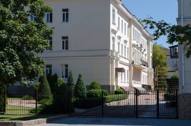 Eski bir binanın restorasyon süreci. Binayı yeniledikten ve yeniledikten sonra üç katlı bir bina. Ön planda süs bahçesi. Hiç kimse olmadan.