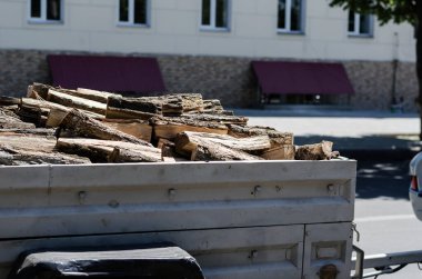 Şehir trafiğinde kesilmiş ahşap kaplı metal römork. Küçük bir araba römorkunda odun kestim. Tahta ve testere kerestesi.