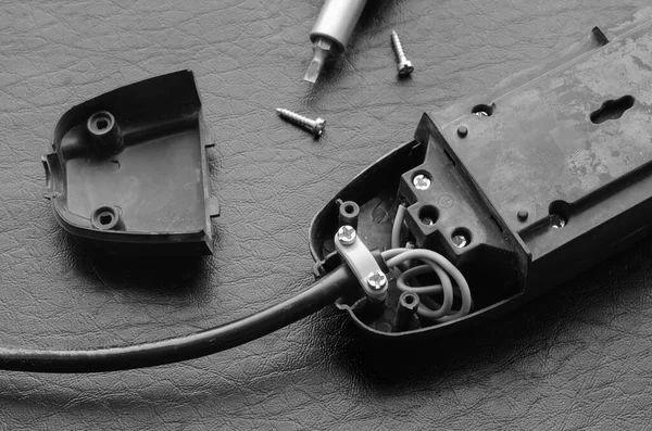 Electric splitter, cable and screwdriver. Connecting wiring to the contacts of the electrical splitter. Top view at an angle. Selective focus.