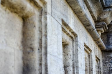 Mermi kayasından yapılmış eski bir binanın ön cephesinin parçası. Dış duvarın kare mimari öğeleri geri çekiliyor. Turizm ve seyahat. Yan görüş. Seçici odak.