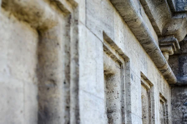 Mermi kayasından yapılmış eski bir binanın ön cephesinin parçası. Dış duvarın kare mimari öğeleri geri çekiliyor. Turizm ve seyahat. Yan görüş. Seçici odak.