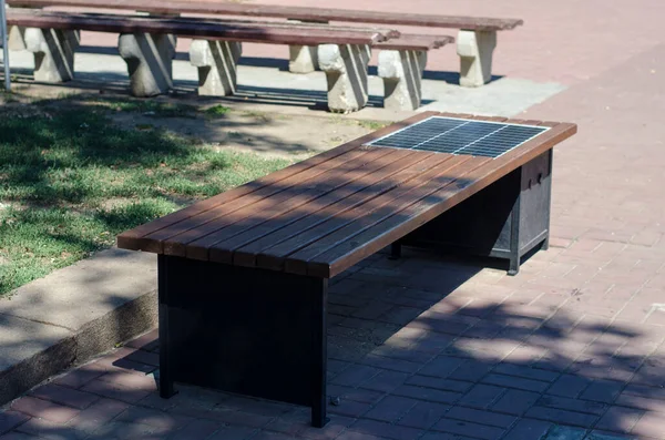 Скамейка Парке Солнечной Панелью Ряд Деревянных Скамеек Способностью Заряжать Гаджеты — стоковое фото