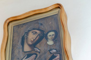 Ukrayna, Nikolaev - 26 Ağustos 2020: kollarında bebek İsa ile Tanrı 'nın annesinin antik simgesi. Büyük bir meşe ağacının çerçevesindeki ikon odanın içindeki duvarda asılı. Bir marangoz solucanı tarafından yenen dini çizikler..