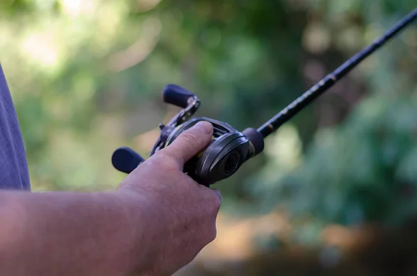 男の手は餌やりのリールを保持します 釣竿で魚を捕まえる白人男性 スポーツとレクリエーション サイドビュー — ストック写真