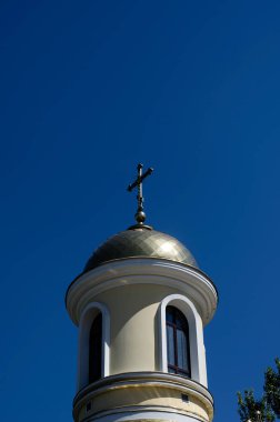 Mavi gökyüzüne karşı bir Ortodoks şapelinin kubbesi. Açık yaz gökyüzünde bir haçla yaldızlı kubbe. İnancın Hıristiyan sembolü. Dini konular.
